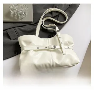 Détail du sac à bandoulière en cuir souple blanc crème avec boucle et plis élégants