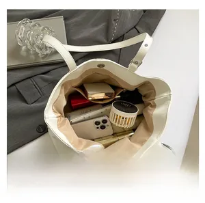 Vue intérieure d'un grand cabas blanc avec compartiments spacieux et poche zippée