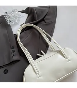 Vue détaillée du sac baguette blanc minimaliste avec deux bandoulières et fermeture éclair