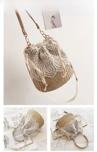 Detailed view of handmade straw bucket bag with white lace floral overlay and drawstring