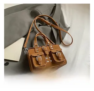 Detail of brown leather motorcycle bag featuring metal rivets and front flap pockets