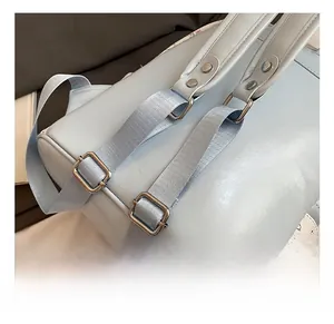 Détail d'un sac à dos bleu clair avec bandoulière réglable et boucle en métal argenté