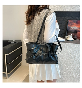 Détail d'un sac cabas plissé noir en similicuir brillant avec décoration de boucle élégante