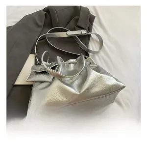 Macro shot of silver metallic leather texture and small square pouch on bucket bag