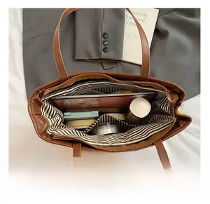 Top view of spacious interior of brown leather tote bag with striped lining for daily commute
