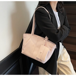 Dettaglio della borsa tote rosa chiaro in finta pelle con pieghe e ciondolo portamonete