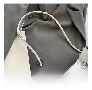 Detail of silver metallic purse showing refined stitching and metal eyelet accents