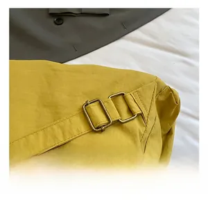 Gros plan sur la bandoulière réglable avec boucle en bronze du sac à dos jaune