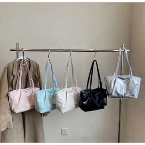 Dettaglio di grandi borse tote in pelle cerata in cinque colori con mini ciondoli coordinati