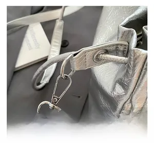 Detailed macro view of metallic silver pleated bag with sturdy metal hooks and strap eyelets