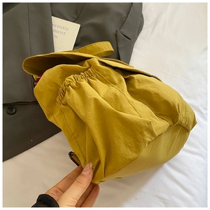 Detail of mustard yellow drawstring backpack side pocket with elastic pleated structure