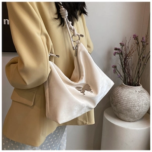 Detail of cream white tote bag with silver butterfly buckle and woven rope strap