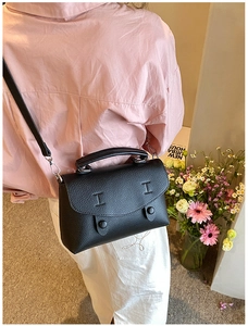 Dettaglio borsa a tracolla in pelle martellata nera con decorazione a rilievo a forma di I