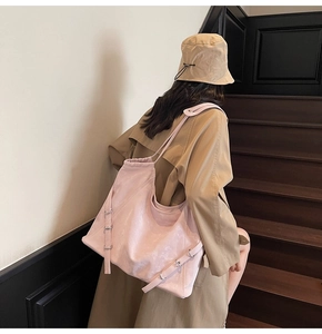 Pink tote bag detail featuring premium lychee texture and metallic buckle straps