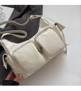 Detail of cream white crossbody bag with dual square front pockets and soft texture