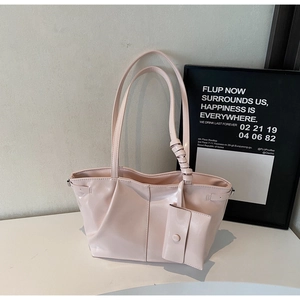 Dettaglio della borsa tote in vernice rosa chiaro con pieghe e mini astuccio