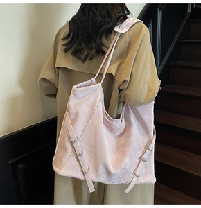 Detailed back view of model wearing a large pink drawstring tote bag with velvet texture