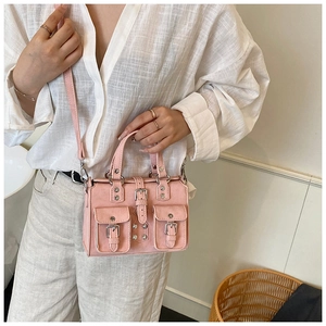 Pink moto-style Boston bag detail with decorative buckle straps and mini front pockets