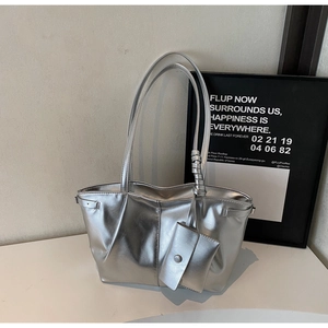 Dettaglio della borsa tote argento metallizzato con texture plissettata e mini pochette