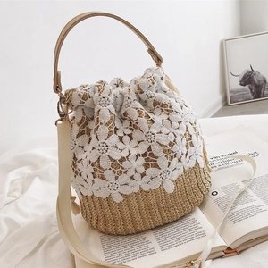 Straw bucket bag with white floral lace, brown leather handle and wide strap