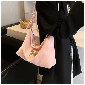 Pink suede hobo bag with silver butterfly accent and unique knotted shoulder strap