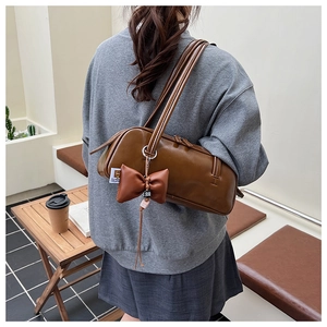 Gros plan sur le sac sous le bras marron vintage avec nœud en cuir et fermeture éclair