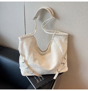 Close-up of cream white tote bag with marble texture leather and silver buckle details