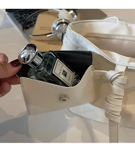Gros plan sur un porte-monnaie en cuir blanc avec bouton pression en argent pour objets