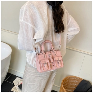 Detailed view of pink multi-pocket crossbody bag with matte faux leather and silver buckles