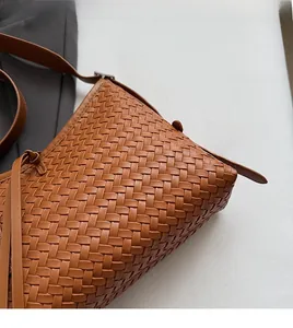 Close-up of caramel brown woven tote bag featuring detailed cross-weave leather texture