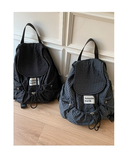 Detail of plaid nylon backpacks with drawstring closures and multiple side pockets