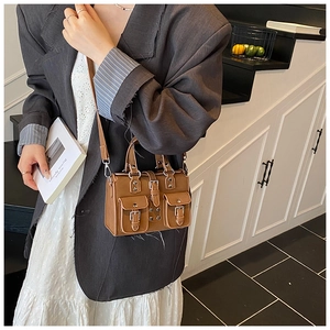 Detail of vintage brown leather crossbody bag with double front flap pockets and buckles