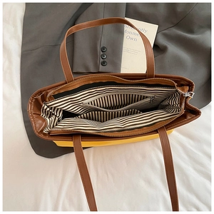 Top view of color-block bucket bag showing striped lining and internal zipper pockets