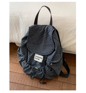 Detailed view of checkered nylon backpack featuring drawstring closure and side pockets