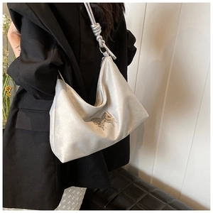 Silver metallic hobo bag with chrome butterfly detail and knotted strap shown on model