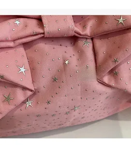 Macro shot of pink twill fabric featuring silver star sequins and fine glitter details