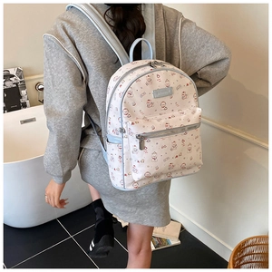 Vue latérale d'un sac à dos blanc à motifs d'ours avec bordures bleu clair sur mannequin