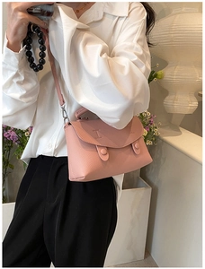 Vista lifestyle della borsa a tracolla in pelle martellata rosa chiaro su una modella