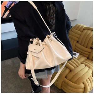 Détail du sac seau plissé crème avec cordon de serrage et charm porte-monnaie assorti