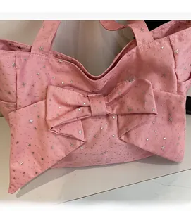 Pink canvas tote bag with silver star prints and a large bow in 45-degree detail view