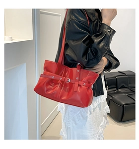 Détail du sac cabas rouge plissé avec boucle argentée et texture en cuir brillant à l'épaule