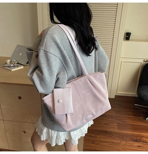 Grand sac fourre-tout rose pâle avec pochette assortie porté à l'épaule