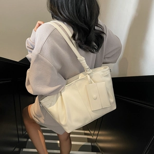 Borsa tote minimalista crema con tracolla a nodo e pochette coordinata su modella