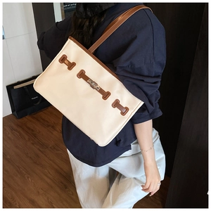 Detail view of contrast color tote bag featuring premium metal buckle and leather strap
