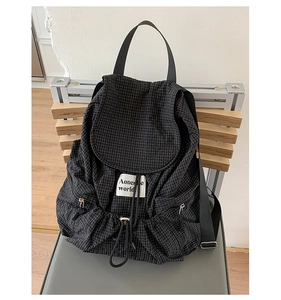 Detailed view of the drawstring closure and checkered nylon fabric on the backpack