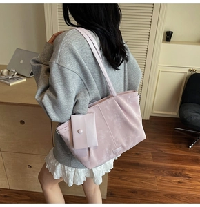 Vue détaillée d'un sac cabas rose poudré avec pochette assortie et texture mate