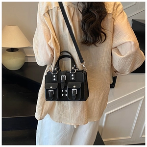 Detail of a chic black moto-style handbag with silver studs and multiple pockets