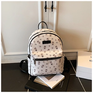 Détail du sac à dos blanc avec imprimé lapin, nœuds noirs et fermeture éclair chromée