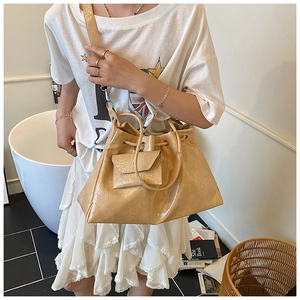 Détail du cabas plissé beige au fini brillant avec sa pochette assortie amovible