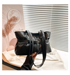 Détail du sac cabas plissé noir avec boucle argentée et fine bandoulière élégante